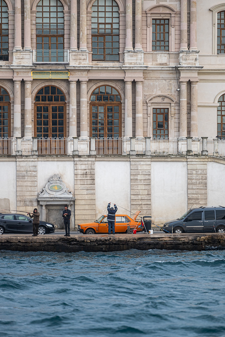Fisherman setting up in front of an orange car