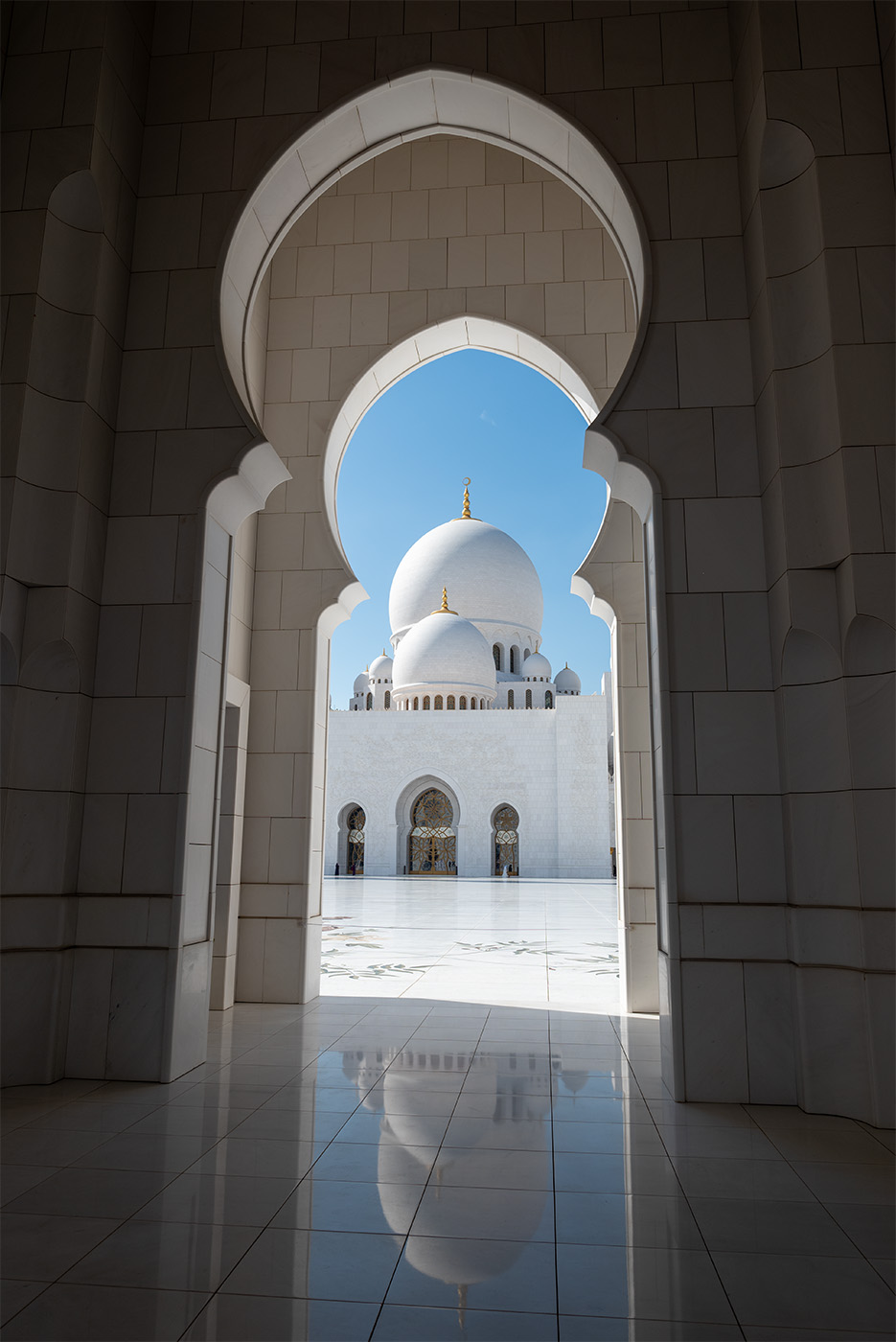 Sheikh Zayed Grand Mosque seen through an archway