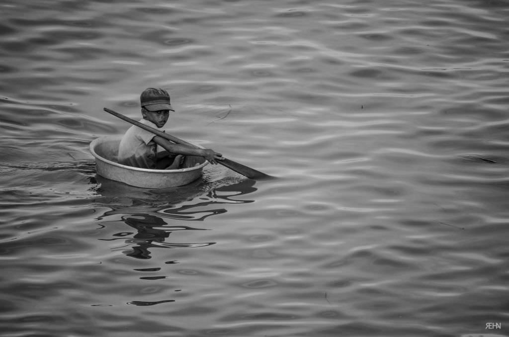 A kid in a tub rowing down the river