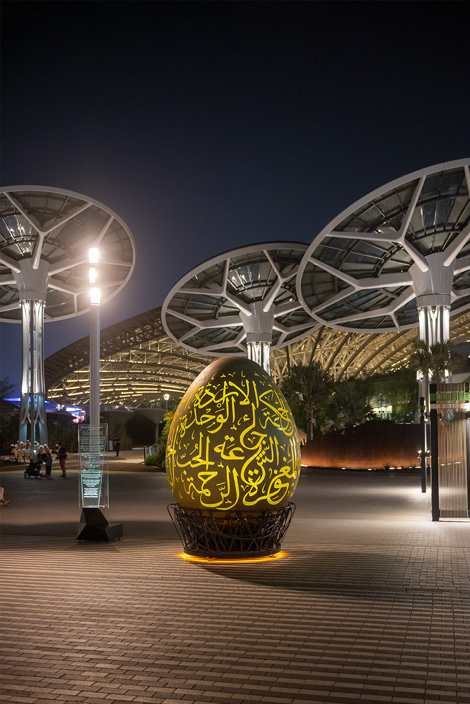 An egg sculpture with arabic script in the courtyard at night