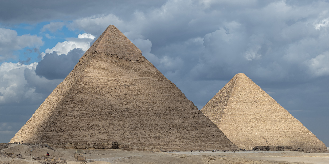 The Pyramids of Giza with a blue sky filled with clouds