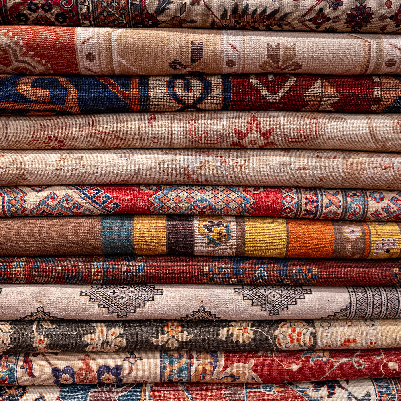 Stack of folded carpets in warm colors
