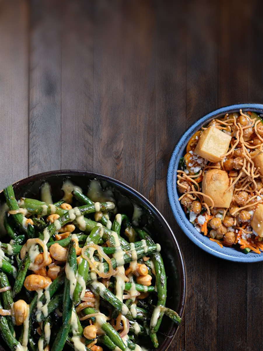 A bowl of green beans and chickpea fritters on a rustic table top