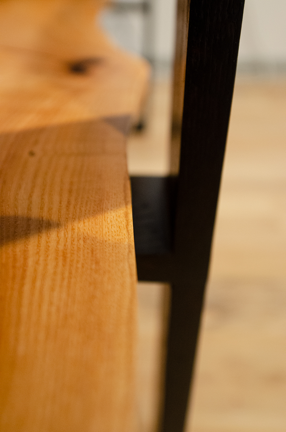 Sofa back table detailing the contrast between the live edge slab and the black sharp legs